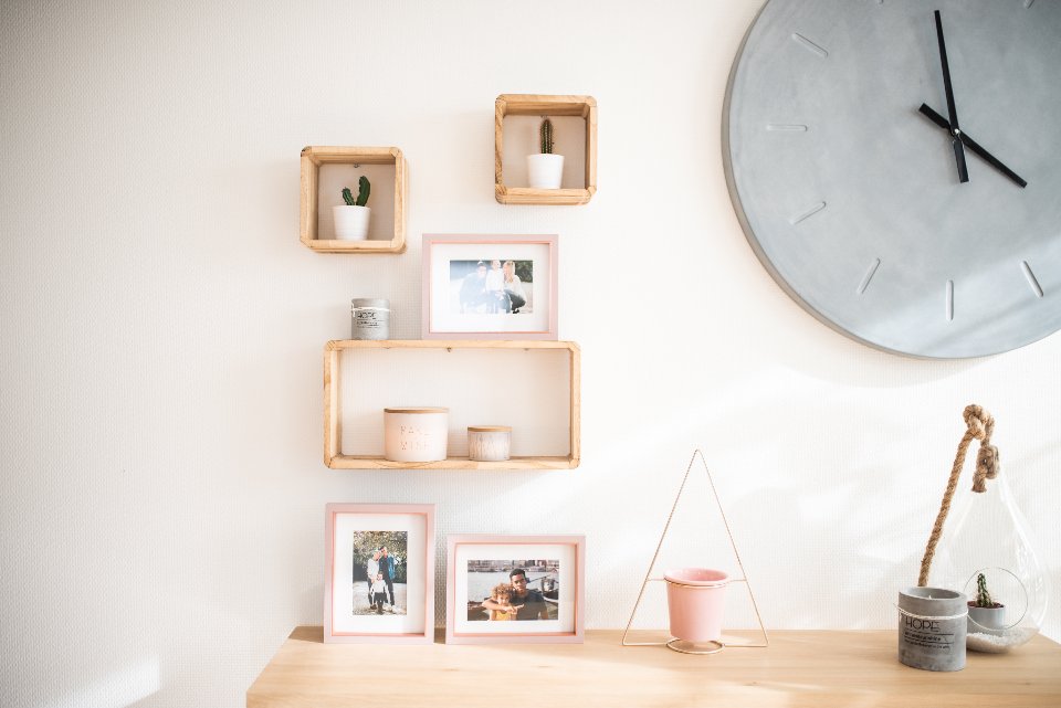 Light shelf display with framed photos and small objects arranged with breathing room
